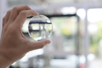 close up of a hand holding a eyeglasses lenses 