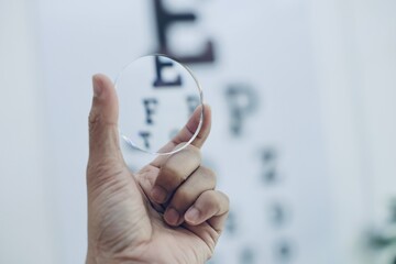 close up of a hand holding glasses lenses 