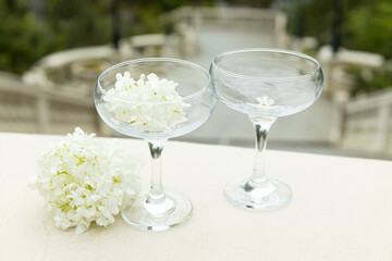 Two glass glasses with flowers on the background of the sea.