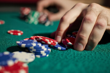 Close-up of vibrant casino chips stacked on a gambling table, colorful chip stacks background and gambler's hands. poker texas hold 'em strategy hand investment investment pot