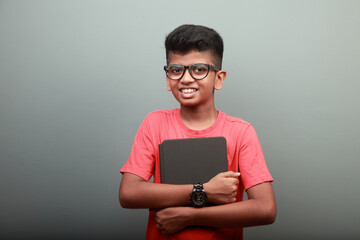 Portrait of a smart Indian ethnic boy holding a tablet computer