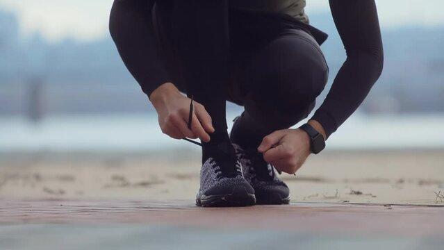 Runner tying shoelaces before jogging workout	