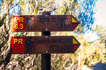 This photo depicts wooden signs in Madeira, indicating directions to. These markings point to the...