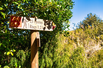 This photo depicts wooden signs in Madeira, indicating directions to. These markings point to the hiking trails leading to these attractions on the island