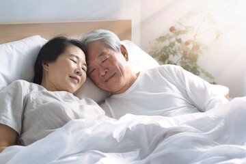 Obraz na płótnie Canvas An elderly Asian man and woman laying together in bed, showcasing love and companionship