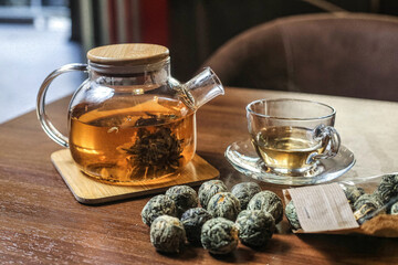 Glass Tea Pot Filled With Green Tea Next to a Cup of Tea