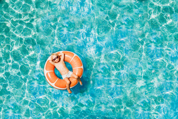 Boy has fun on family vacation rest in pool with donut ring