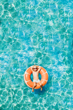 Drone aerial Cool kid orange floaties swimming pool hot summer