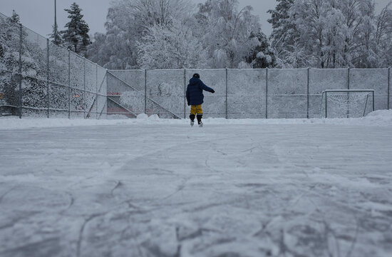child ice skating outside in their garden in Sweden