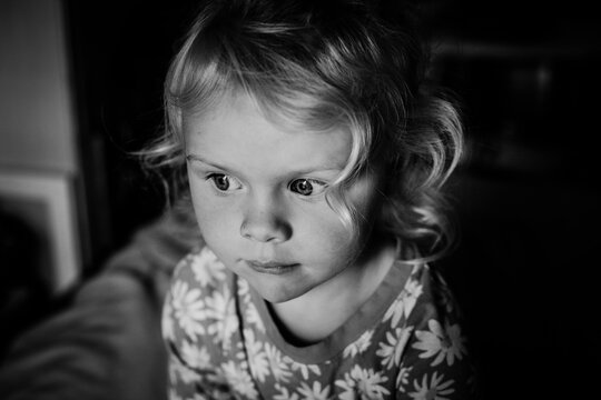 Casual black and white portrait of toddler girl with curly hair