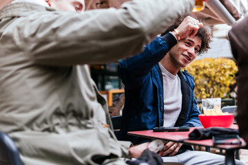 four multi ethnic friends drinking beers and talking
