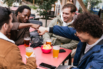 four multi ethnic friends drinking beers and talking