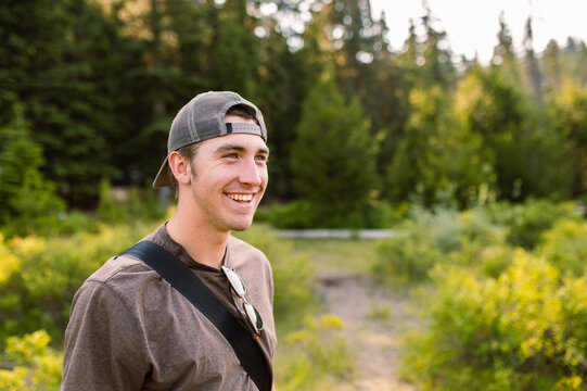 Smiling man with cap in forest setting