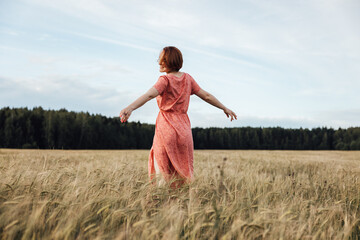 Girl dancing in the field on a summer day