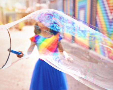 Young Girl Making Huge Bubble in front of a mural in Washington, DC