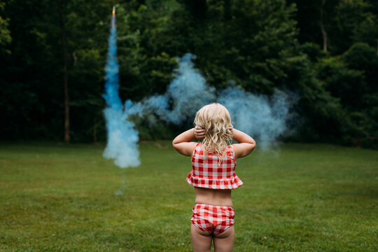 Young girl watching fireworks covering ears on 4th of July