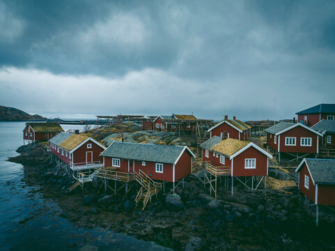 Drone shot of stilt houses at island in front of cloudy sky
