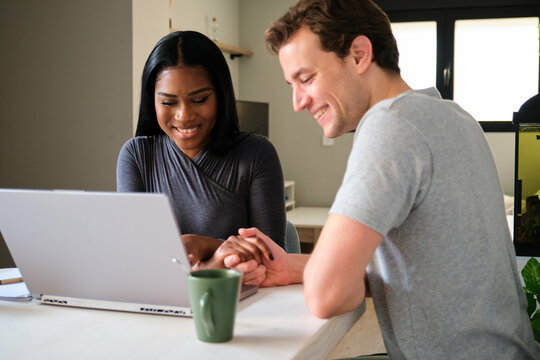 Multiethnic couple getting a good news from a video call.