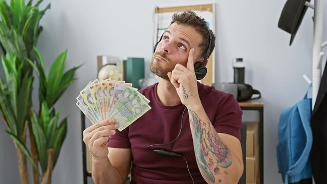 Handsome young office guy, sporting a cheeky grin, pointing a victory number one with his finger - a 'lightbulb moment' with a romanian lei banknotes idea in his headset chatter!
