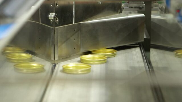 Lid sealing process on jars at a production line in a factory