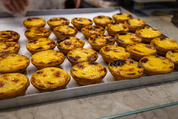 Traditional Portuguese Pastel De Nata pastries on pastry shop counter in Lisbon