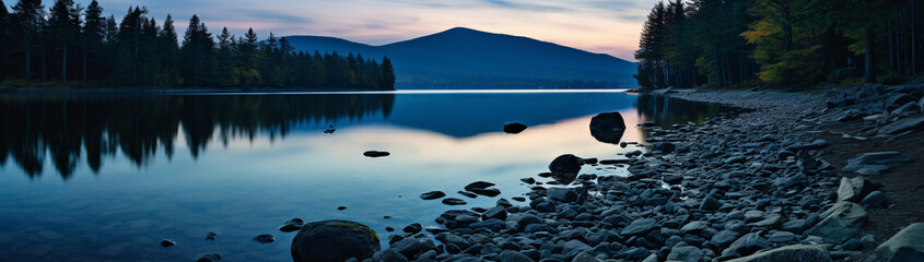 Ripples on a tranquil blue mountain lake at dusk.