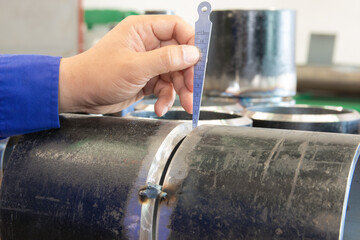 QC inspectors measure the root gap of the workpiece with a taper gauge before welding.