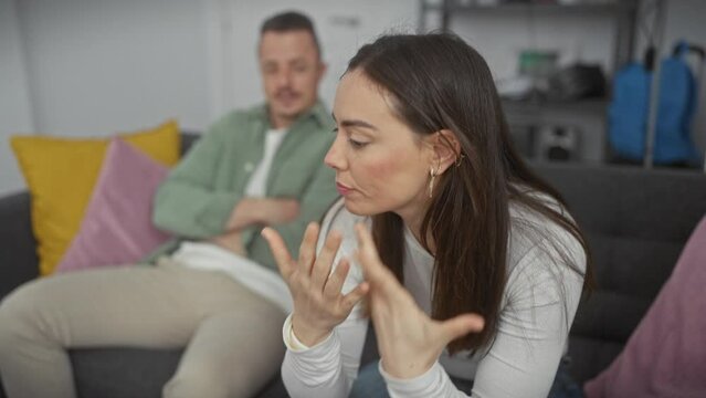 Upset woman and indifferent man sitting on a couch in a modern living room during an argument