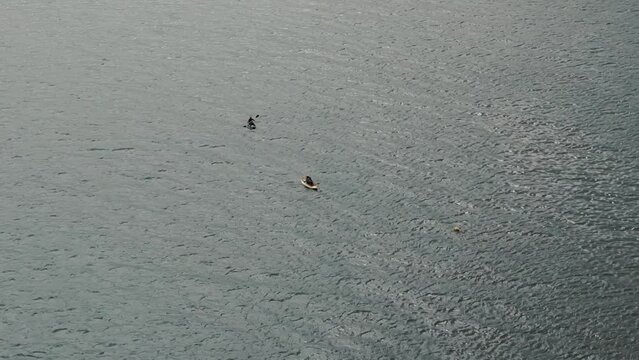 Kayaks gracefully navigate the calm waters of the Atlantic Ocean.