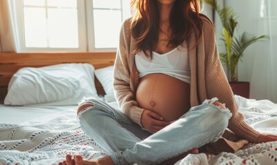 Pregnant woman with visible belly sitting on bed - obrazy, fototapety, plakaty