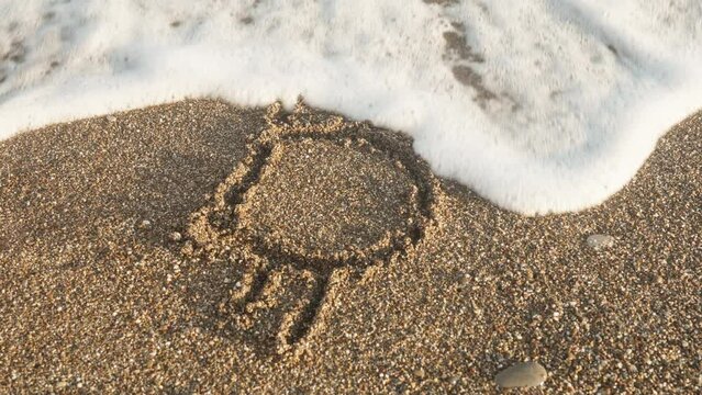 The inscription on the sand washes away with a wave. Bitcoin. Summer, sea, beach. In motion.