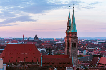 Red morning sunlight indirectly shining on the buildings and church towers of the city of nurmberg