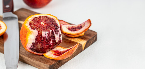 Cleared of peel Red blood orange on a wooden board, cooking dish. Long banner format. top view....