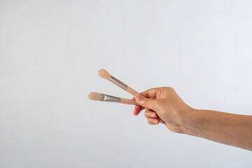 Cosmetic brushes in hand on white background. Set of makeup brushes