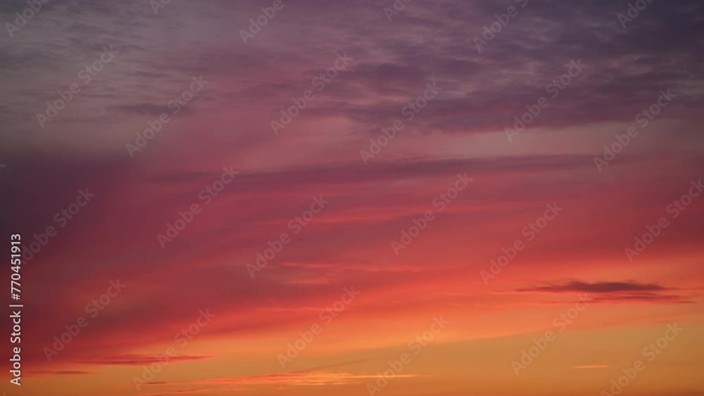 Wall mural an abstract background of red-orange clouds in the dark evening sky, abstract timelapse