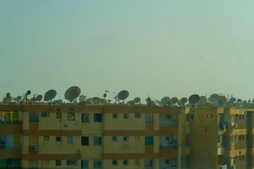 Cluster of dish antennaes fitted on the roof top of apartments