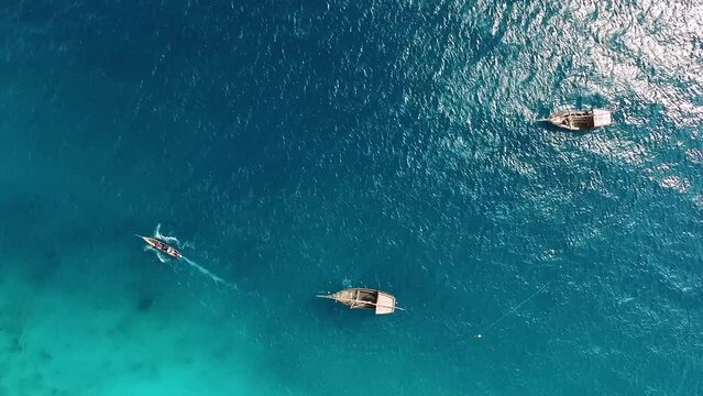 Fishing Boat Moving By Turquoise Ocean Surface Through Floating Fishing Boats Near Zanzibar Island