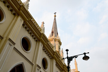 Church Roof with a cross. Church building roof with holy cross. Cloudy moody blue sky background. Minimal architecture design and detail. Exterior design and detail. 