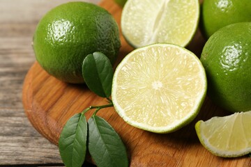 Fresh ripe limes on wooden table, closeup