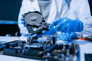 Obraz premium Technician repairing inside of hard disk drive by screwdriver. the concept of data, hardware, technician and technology. computer hardware, upgrade .