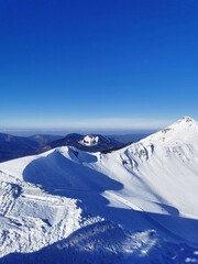 Pristine mountain snowscape under a clear blue sky. - 770481535