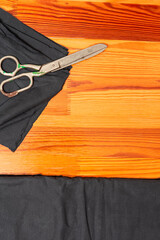 Process of Cutting Textile Cloth at Work Table With old Rusty Scissors and Black Fabric - 770484331