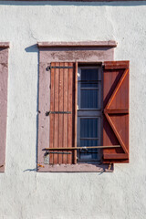 Vintage window with shutters on the wall of an old house..window in Cunda Turkey old construction and wood the historical
