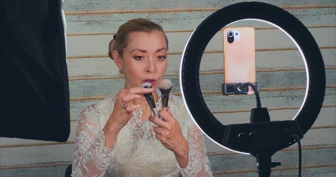 Blonde woman conducts an online master class on applying makeup