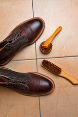 Various Shoes Cleaning Accessories for Dark Brown Grain Brogue Derby Boots Made of Calf Leather Over Tile Background - 770486119