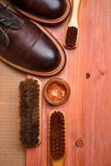 Flatlay of Various Shoes Cleaning Accessories for Dark Brown Grain Brogue Derby Boots Made of Calf Leather Over Paper Background - 770486533