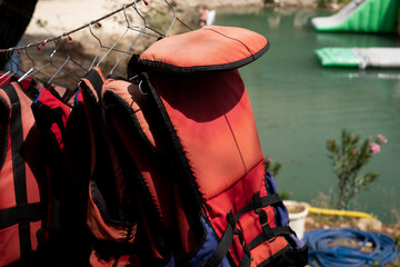 Life jackets hanging against the backdrop of the sea. For sale: lifesaving equipment for marine...