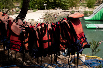 Fototapeta premium Life jackets hanging against the backdrop of the sea. For sale: lifesaving equipment for marine excursions and tours, emphasizing safety on cruises and yacht outings. Marine services and training.