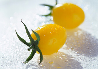 Fresh yellow tomatoes on icy background