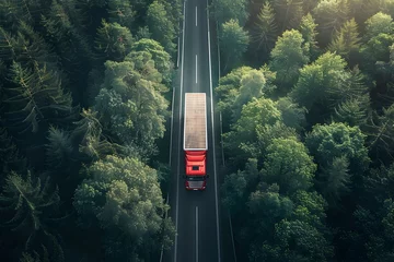 Foto op Plexiglas Aerial View of Red Cargo Truck Navigating Winding Forest Road Through Lush Green Landscape for Logistics Transportation © TEERAWAT